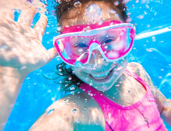 Kleines Mädchen schwimmt im Pool. — Stockfoto