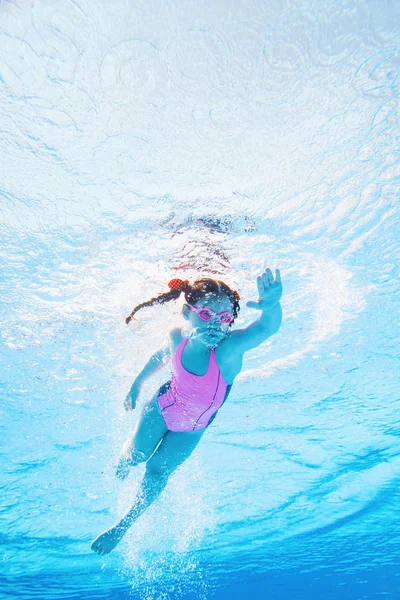 Kleines Mädchen schwimmt im Pool. — Stockfoto