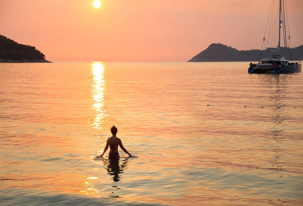 Meisje zwemt bij zonsondergang — Stockfoto