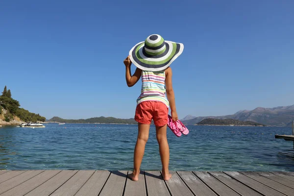 小女孩在大帽子享受海滩和日光浴在海滨度假胜地 — 图库照片