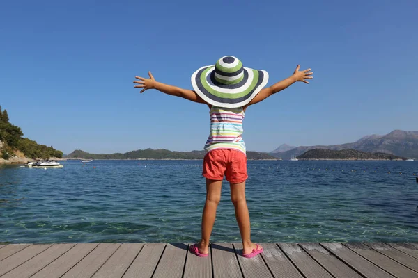 ビーチで楽しむ 海リゾートで日光浴を大きな帽子の少女 — ストック写真
