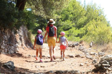 Anne iki kızı ile dağlarda güzel bir yol boyunca seyahat
