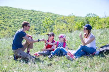 Bir zammı Dağları ile bir çayır üzerinde iki çocuklu aile