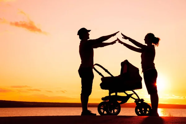 Счастливая семья, гуляющая на закате — стоковое фото