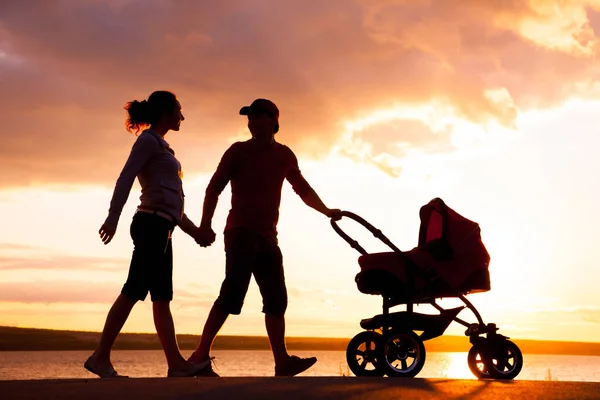 Família feliz andando no pôr do sol — Fotografia de Stock