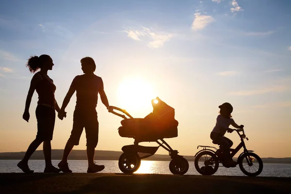 Sunset bulvarında yürürken mutlu bir aile — Stok fotoğraf