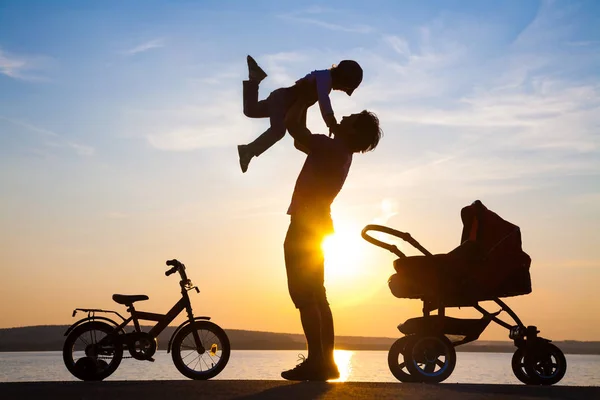 Père heureux avec enfant au coucher du soleil — Photo