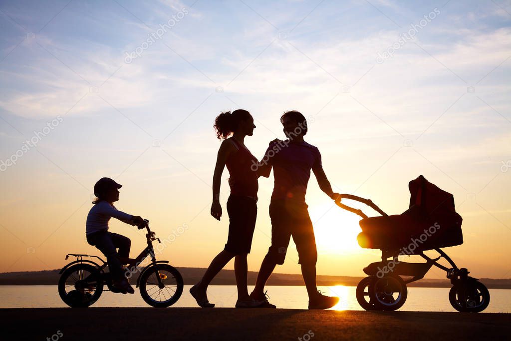 happy family walking on sunset