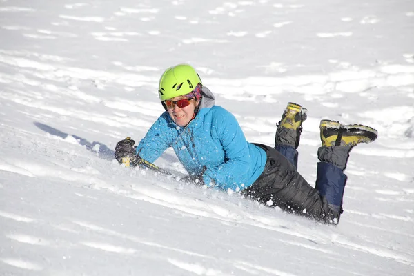 登山家の女性は雪の中で氷斧をハッキングして山から転げ落ち — ストック写真