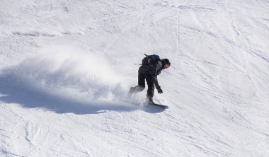 Kar kayakçıları bir kayak merkezinde kar yamacından aşağı yuvarlanırlar.