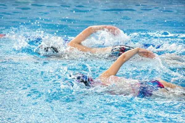 two kids swimming in the pool at the training in swimming