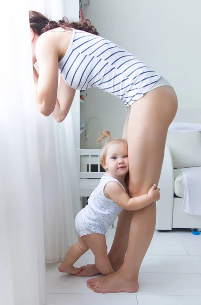 Anak Kecil Memeluk Kaki Ibu Ketika Dia Bersandar Depan Cermin — Stok Foto