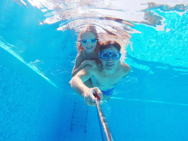 スイミングプールにいる少女と若いお父さんの水中写真 — ストック写真