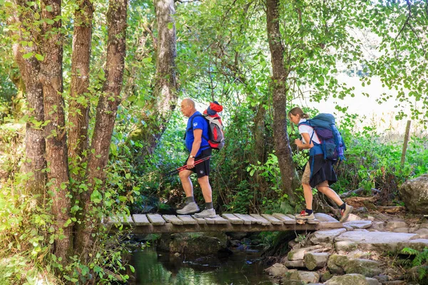 Hikers crossing foot bridge — Stock Photo, Image