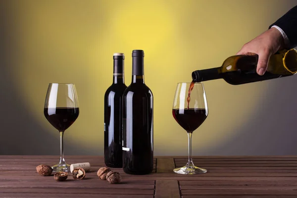 Male hand holding bottle of red wine — Stock Photo, Image