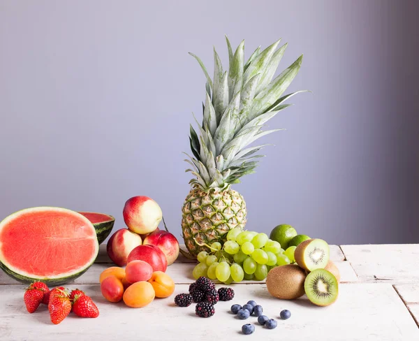 Verschiedene Früchte auf dem weißen Holztisch — Stockfoto