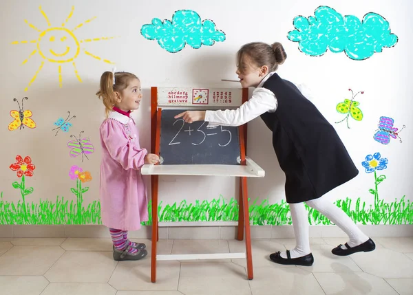 Menina ensinando matemática a uma criança mais nova — Fotografia de Stock