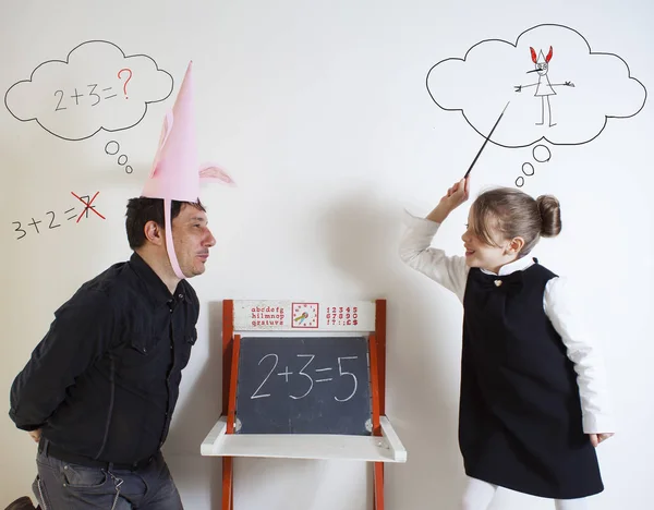 Little girl teaching mathematics to an adult dunce — Stock Photo, Image