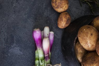 Taze soğan ve patates koyu arka plan üzerinde