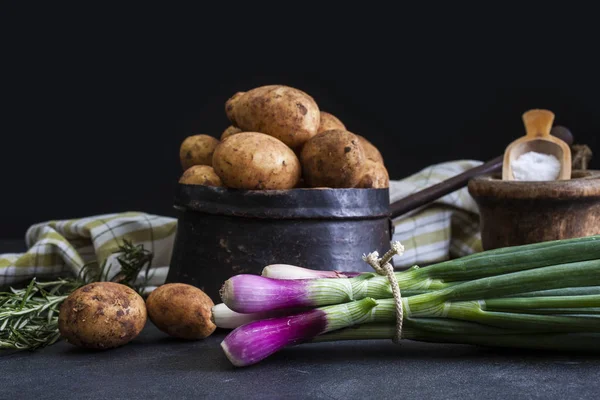 Lente-uitjes en aardappelen op donkere achtergrond — Stockfoto
