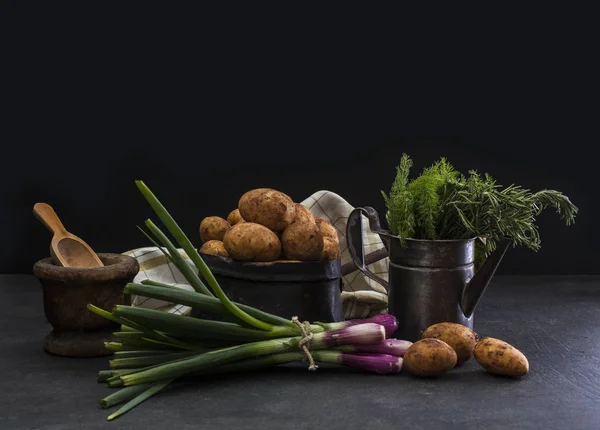 Cebolinhas e batatas no fundo escuro — Fotografia de Stock
