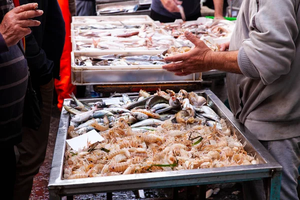 Salesman selling sea cicadas in the street fish market, Catania — Stock Photo, Image