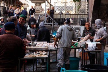  Satış elemanı ve turistler tipik sokak balığı işaretinde.