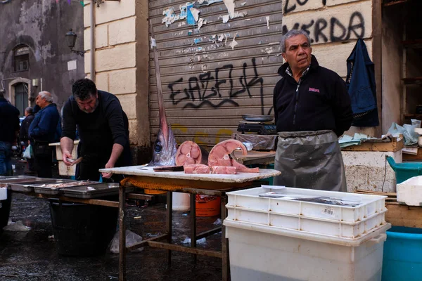 Vendedor junto a su puesto de pescado en el mercado de pescado de la calle — Foto de Stock