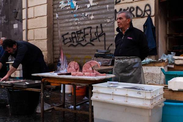 Vendedor junto a su puesto de pescado en el mercado de pescado de la calle —  Fotos de Stock