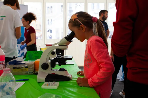 Девчонки изучают науку за микроскопом — стоковое фото