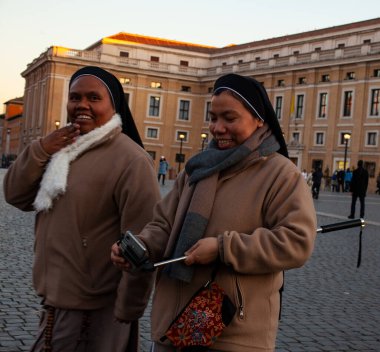 Roma, İtalya - 8 Ocak 2020 'de Vatikan' daki Aziz Peter Meydanı 'nda iki rahibe selfie çubuğu kullandı.