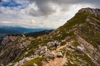 Sırt çantalı genç kadın güney Julian Alpleri 'nin Vogel Dağı manzaralı bölümünde yürüyüş yapıyor ve Slovenya' nın Triglav Ulusal Parkı mirası