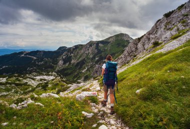 Sırt çantalı genç kadın güney Julian Alpleri 'nin Vogel Dağı manzaralı bölümünde yürüyüş yapıyor ve Slovenya' nın Triglav Ulusal Parkı mirası