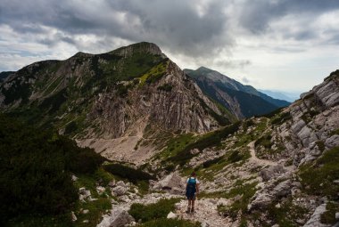 Sırt çantalı genç kadın güney Julian Alpleri 'nin Vogel Dağı manzaralı bölümünde yürüyüş yapıyor ve Slovenya' nın Triglav Ulusal Parkı mirası