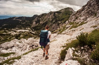 Sırt çantalı genç kadın güney Julian Alpleri 'nin Vogel Dağı manzaralı bölümünde yürüyüş yapıyor ve Slovenya' nın Triglav Ulusal Parkı mirası