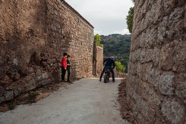 LOLLOVE, SARDINIA / OCTOBER 2019: Kids playing with a motorbike — Stock Photo, Image