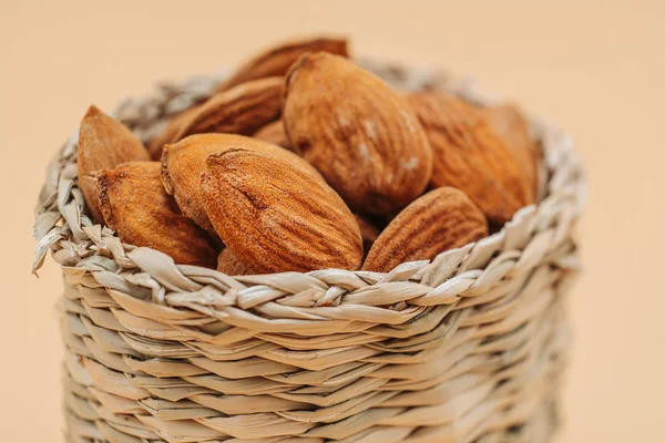 Healthy organic dried almonds in a straw basket — Stock Photo, Image