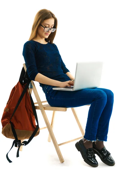 Mädchen sitzt auf einem Stuhl mit Laptop — Stockfoto