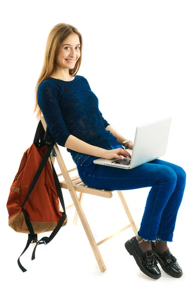 Flickan sitter på en stol med laptop — Stockfoto