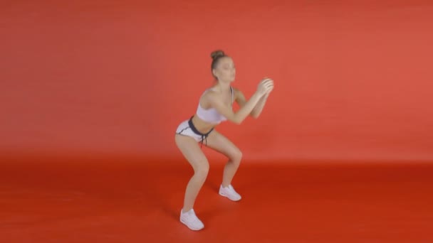 A menina está se aquecendo, flexionando articulações, agachamentos — Vídeo de Stock