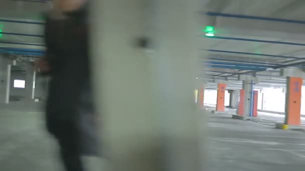 Um jovem casal corre através do estacionamento . — Vídeo de Stock