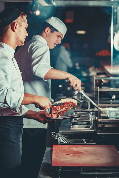 Chefs ocupados en el trabajo en la cocina del restaurante — Foto de Stock