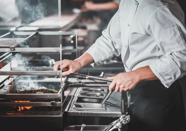 Busy chef at work in the restaurant kitchen — Stock Photo, Image