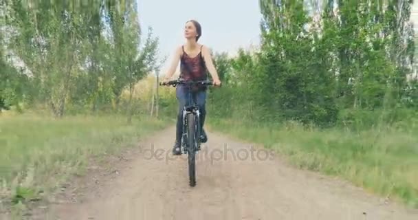 Девушка ездит на велосипеде в сельской местности — стоковое видео