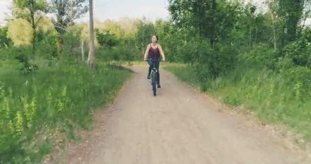 Meisje rijdt een fiets op het platteland — Stockvideo