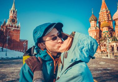 Happy tourists kissing on Red Square, Moscow clipart