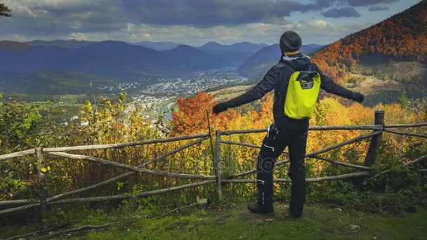 Ung man att höja händerna på mountain utsiktsplats — Stockvideo