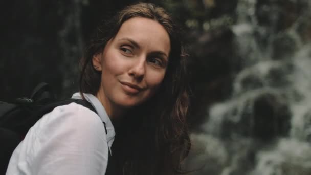 Kvinna turist nära stänk vattenfall porträtt — Stockvideo