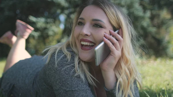 Glädjande ung kvinna spela långt hår mobiltelefon samtal — Stockfoto