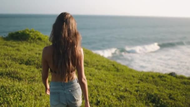 Slim woman walking to banawa beach cliff edge — 비디오